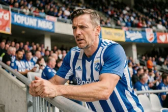 Supporter du Racing Club de Strasbourg accroché à la rambarde du stade, regardant le match avec intensité lors d'une rencontre de Ligue 1 2026